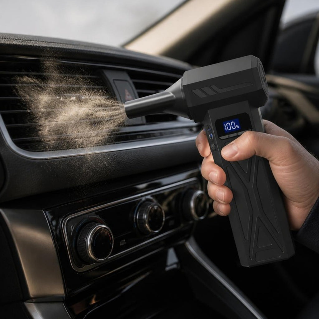 Cordless air blower clearing dust from a car air vent