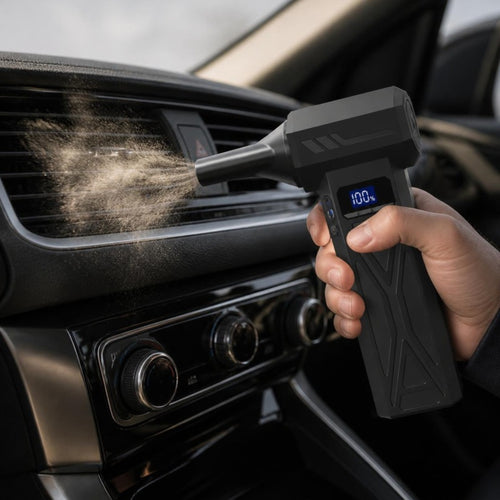 Cordless air blower clearing dust from a car air vent